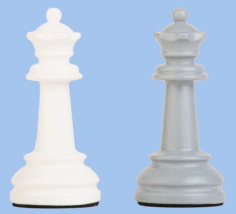 Zwei Schachkönige aus Kunststoff in Weiß und Grau vor blauem Hintergrund, Nahaufnahme des Figuren-Designs